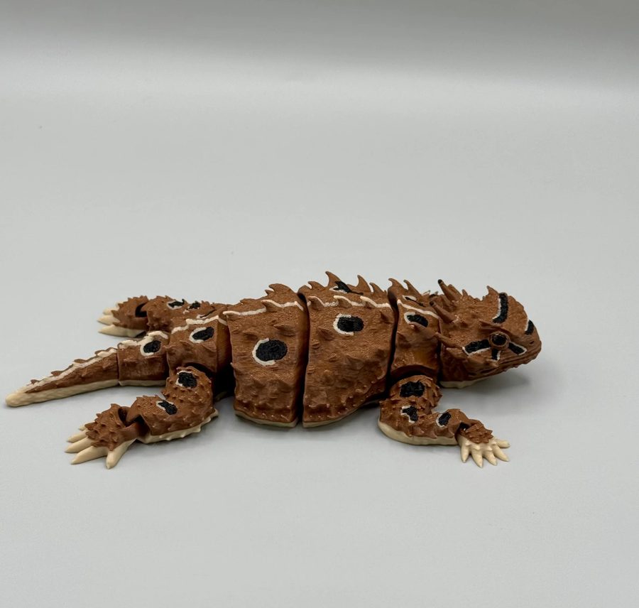 3D printed articulated horned lizard in brown with black eye spots and pale spikes